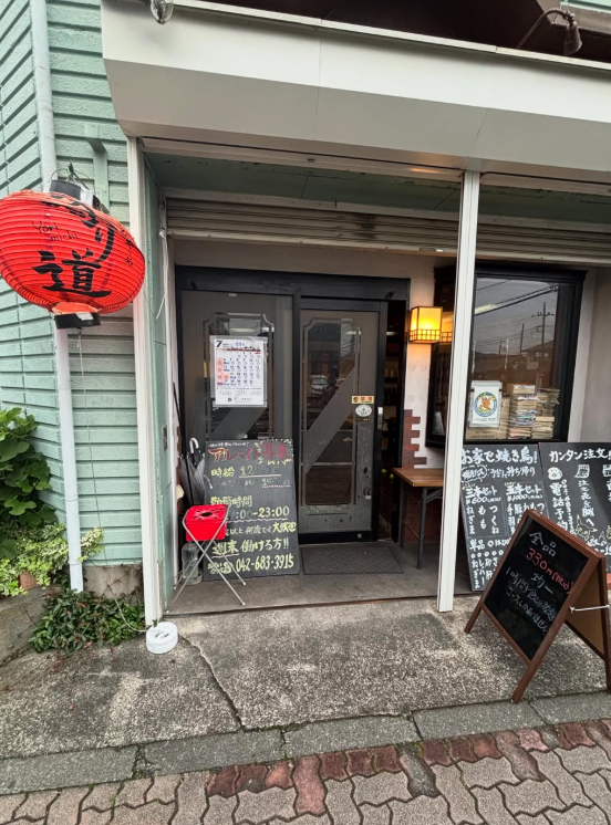 赤提灯が下がる寄り道の店構え。黒板メニューが並ぶ入口